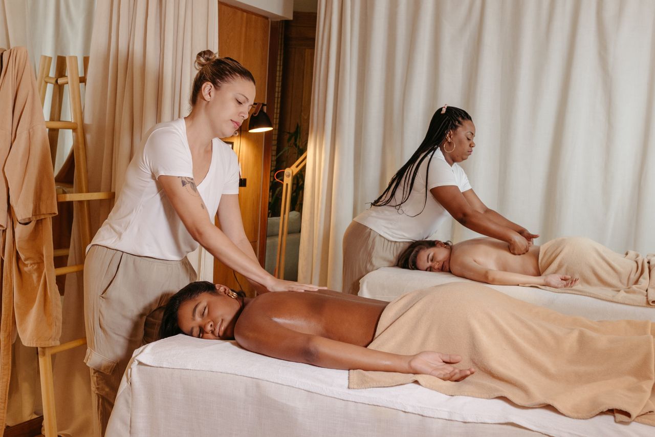 services-04 Two women receiving relaxing massages in a serene spa setting, enhancing wellness.